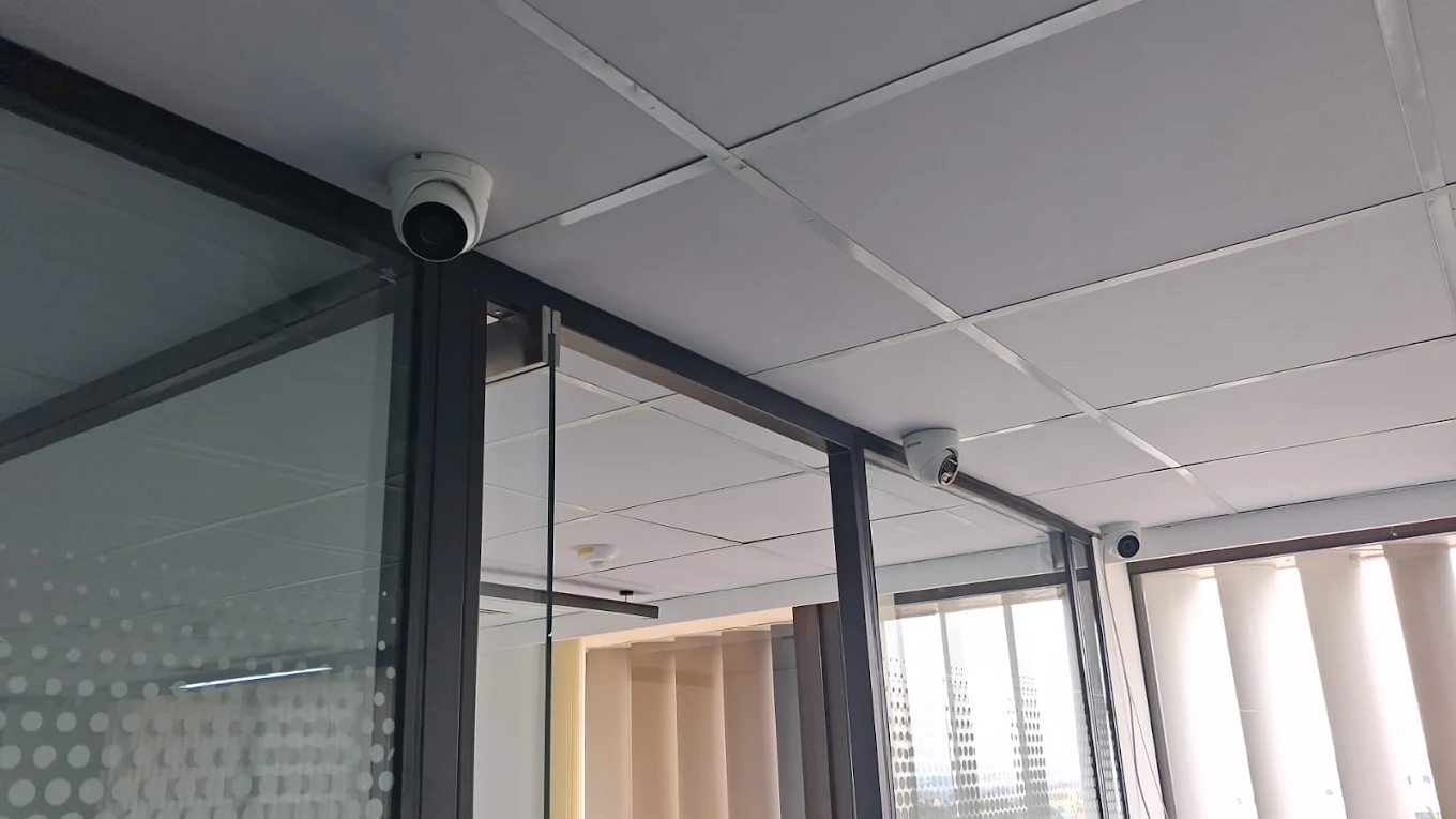 Dome CCTV cameras installed across a modern office ceiling